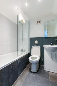 y baño con aseo, lavabo y ducha. en Bower House en Londres