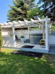 a white pergola with a grill on a patio at Przystań Jagoda - pokoje i domki in Ostrowo