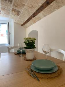 a wooden table with a green plate and glasses on it at Nonna Rosa Maison in Monopoli +6 photos
