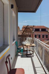 uma varanda com 2 cadeiras e uma mesa na varanda em Bed Station Hostel & Bar em Shkodër