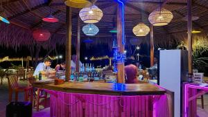a bar in a restaurant with people sitting at it at Salabose Cottages in Gili Islands