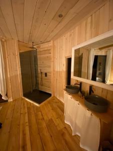 a bathroom with two sinks in a wooden room at LES CABANES DE LUTINA 