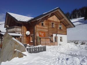 a log cabin in the snow with a ramp in front at Almrauschhütte Markus in Lachtal
