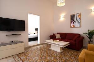 sala de estar con sofá rojo y TV en Traditional 2 bedroom house with yard SSCH1, en San Julián