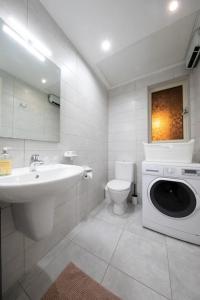 een badkamer met een wastafel en een wasmachine bij Traditional 2 bedroom house with yard SSCH1 in St Julian's