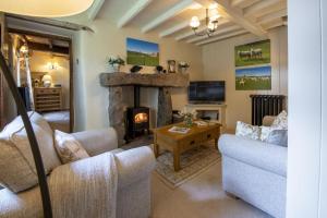 a living room with a fireplace and a couch at Duxey Cottage in Thornton Steward