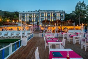 a restaurant on the water with tables and chairs at Akyalı Boutique Hotel in Guvercinlik