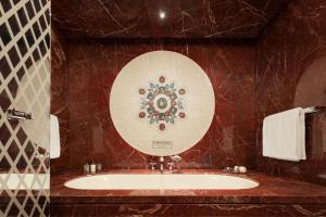 bagno con lavandino e specchio di Bulgari Hotel Roma a Roma