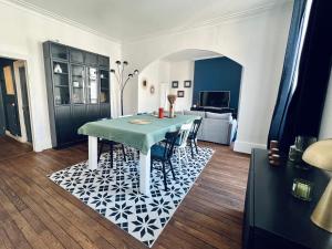 a dining room with a table and chairs on a rug at "Le Général" Appartement prestige proche gare, haut-de-gamme, avec billard et parking privé in Nevers