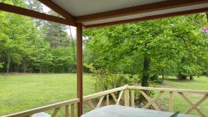 a screened in porch with a view of a yard at CAMPING HERMITAGE DES 4 SAISONS in Saint-Julien-de-Bourdeilles