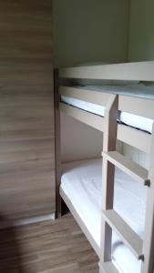 a room with a bunk bed with white shelves at CAMPING HERMITAGE DES 4 SAISONS in Saint-Julien-de-Bourdeilles