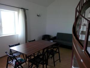 a dining room with a table and chairs and a couch at Vila Antonia in Eforie Nord