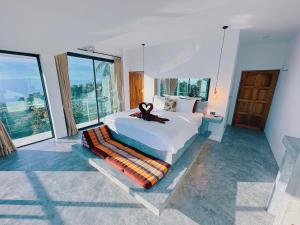 a bedroom with a large bed and large windows at Villa Valentin in Salad Beach