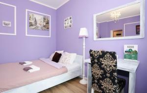 a purple room with a bed and a mirror at Apartament Lawendowy in Wałbrzych