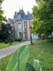 uma casa com uma grande folha verde em frente em Le Temps d'un Rêve em Ravenel