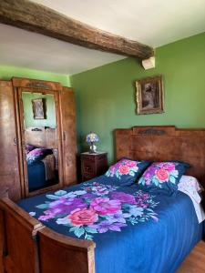 sypialnia z łóżkiem z niebieską kołdrą i lustrem w obiekcie Le Temps d'un Rêve w mieście Ravenel