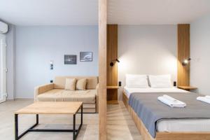 pokój hotelowy z 2 łóżkami i kanapą w obiekcie Unique Aura Luxury Studios w mieście Neos Marmaras