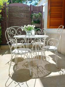 un tavolo bianco e sedie su un patio di DIMORA ARTEMISIO a Siponto