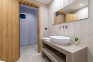 łazienka z białą umywalką i lustrem w obiekcie Unique Aura Luxury Studios w mieście Neos Marmaras +37 zdjęć