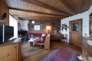 a living room with a couch and a tv at Chalet Magdalena in Avelengo