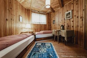 a bedroom with two beds and a table in it at Chalet Magdalena in Avelengo