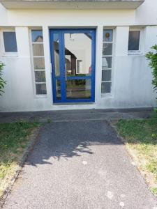 uma casa com uma porta azul ao lado dela em 2 pièces à deux pas de la plage. em Fouesnant