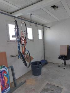 uma garagem com duas bicicletas penduradas numa parede em 2 pièces à deux pas de la plage. em Fouesnant