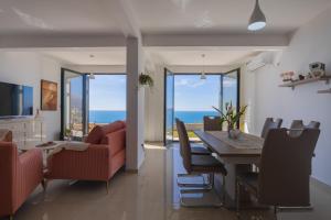 a dining room and living room with a table and chairs at Villa Krstac in Budva