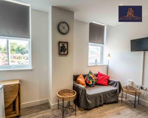 a living room with a couch and a clock on the wall at Swan House Apartment 4 - 1 Bed Apartment - Sleeps up to 4 - Free Parking - Liverpool - close to city centre - By ALL ELITE STAYS in Liverpool