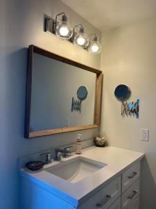 a bathroom with a sink with a large mirror at OH Victoria Hotel in Hampton 