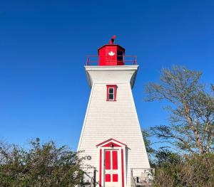 a red and white lighthouse with a clock on it at OH Victoria Hotel in Hampton 