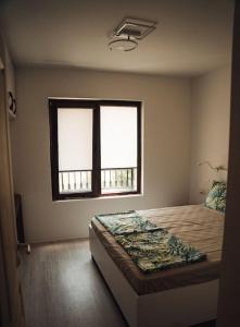 1 dormitorio con cama y ventana en Lovely apartment near Kavatsi en Sozopol