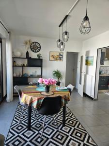 une salle à manger avec une table et des chaises dans une pièce dans l'établissement Appartement de charme , Royan, proche mer avec balcon., à Royan