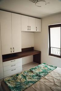 a bedroom with a bed and white cabinets and a window at Lovely apartment near Kavatsi in Sozopol