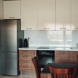 una cucina con frigorifero, tavolo e sedie di Lovely apartment near Kavatsi a Sozopol