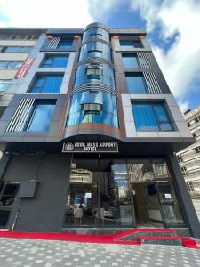 Un edificio alto con un cartel delante. en Royal Mass Airport Business Hotel, en Arnavutköy