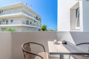 a table and chairs on a balcony with a building at Elegant Suite 3 Near the Beach in Ayía Marína