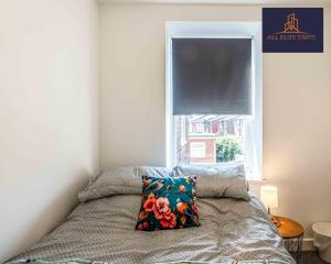 ein Schlafzimmer mit einem Bett mit Kissen und einem Fenster in der Unterkunft Swan House Apartment 2 - 1 Bed Apartment - Sleeps up to 4 - Free Parking - Liverpool - close to city centre - By ALL ELITE STAYS in Liverpool