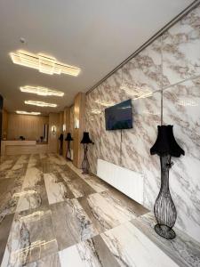 a lobby with a marble wall with a lamp on it at Royal Mass Airport Business Hotel in Arnavutköy