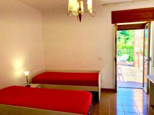 a room with a red bed and a sliding glass door at Il Ciliegio in Stella Cilento