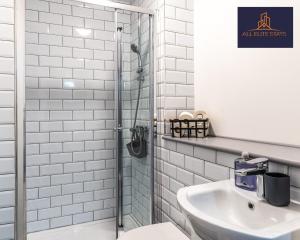 ein Bad mit einer Dusche und einem Waschbecken in der Unterkunft Swan House Stunning 1 bed Apartment By ALL ELITE STAYS - near Liverpool city centre - Sleeps 4 - Free Parking in Liverpool