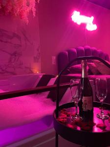 ein lila Zimmer mit einer Flasche Wein und zwei Gläsern in der Unterkunft Superbe appartement avec Balnéothérapie/spa/ Champagne in Pornic