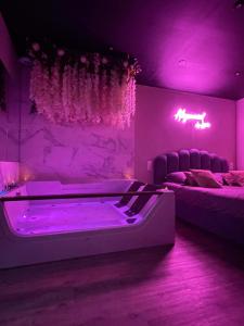 Dieses lila Zimmer verfügt über eine Badewanne und 2 Betten. in der Unterkunft Superbe appartement avec Balnéothérapie/spa/ Champagne in Pornic