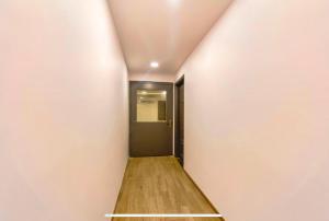 a hallway with a black door and a wooden floor at FabHotel Heera Holiday Inn in Kolkata
