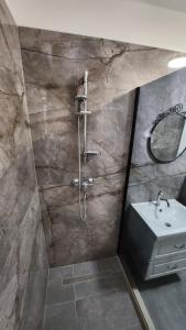 ein Bad mit einer Dusche und einem Waschbecken in der Unterkunft Hidden Sunset in Selca