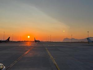 an airport with planes parked on the runway at sunset at Fiori d'Arancio in Terrasini