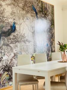 een eettafel met stoelen en een groot schilderij aan de muur bij Studio mit Küche in Pirna