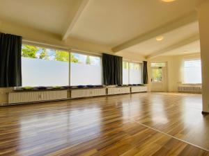 a large room with a wooden floor and large windows at Studio mit Küche in Pirna