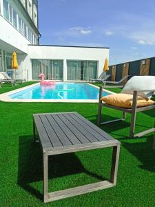 una piscina con tavolo in legno, panca e piscina di ibis Styles Poitiers Nord a Poitiers