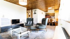 a living room with chairs and a table and a tv at Ferienwohnung Chalet Bortelhorn in Termen